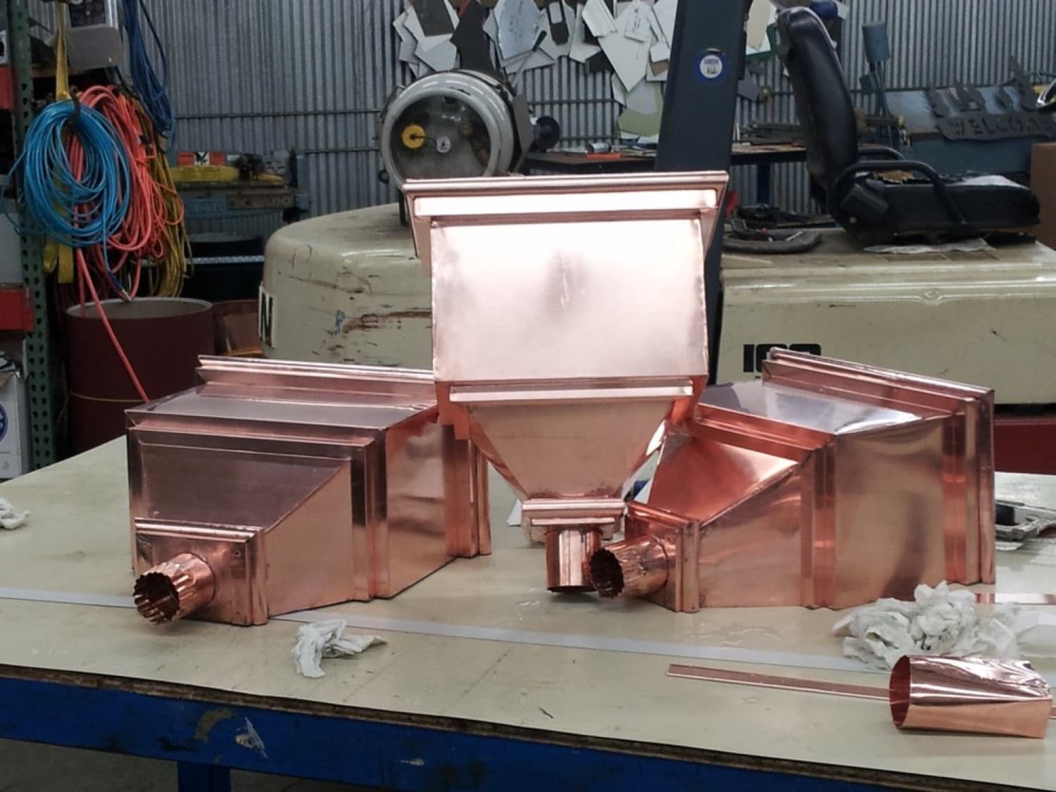 Custom-fabricated copper scuppers and leader heads for commercial roof drainage